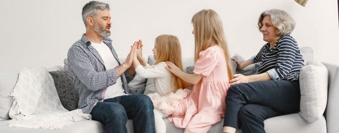 A joyful family spends quality time together, playing and bonding on a cozy sofa.